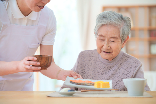 食事の準備をする介護職員と高齢者