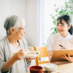 食事摂取について記録する介護士