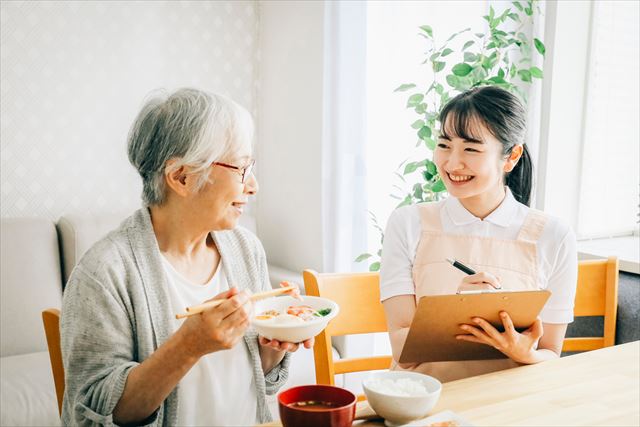 食事摂取について記録する介護士