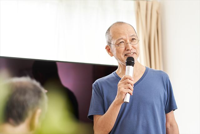 高齢者施設のカラオケ大会に参加する高齢者