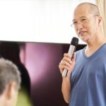 介護施設でカラオケのレクリエーションを楽しむ高齢者
