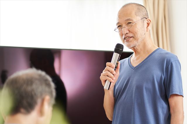 介護施設でカラオケのレクリエーションを楽しむ高齢者