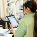 ケアサポートつるみ　職員がタブレットを操作する様子