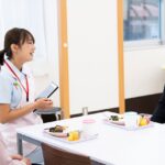 ご利用者と会話し、介護記録を取る看護職員